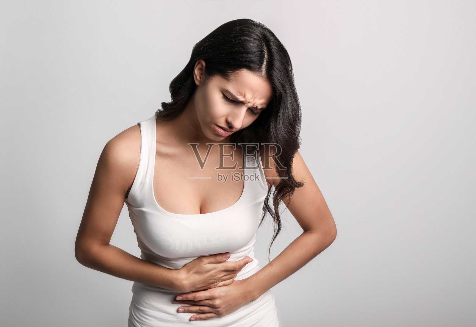 年轻女子胃痛在灰色背景照片摄影图片