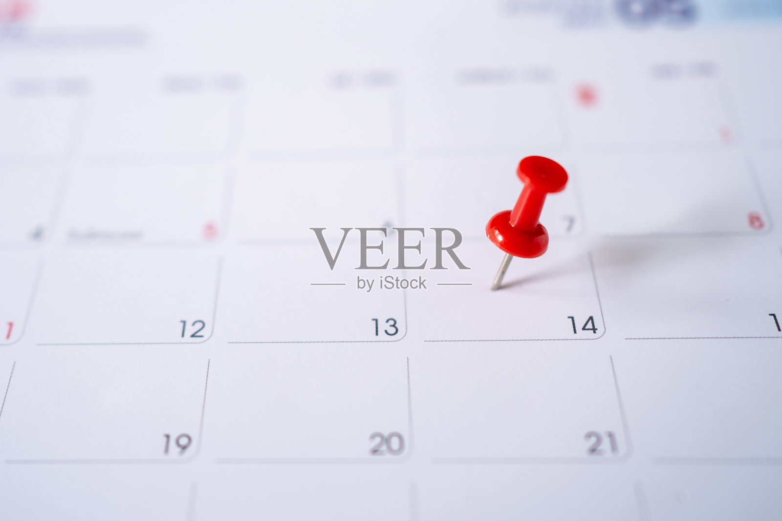 红色大头针上绣着日历上的第十四。有选择性的重点。照片摄影图片