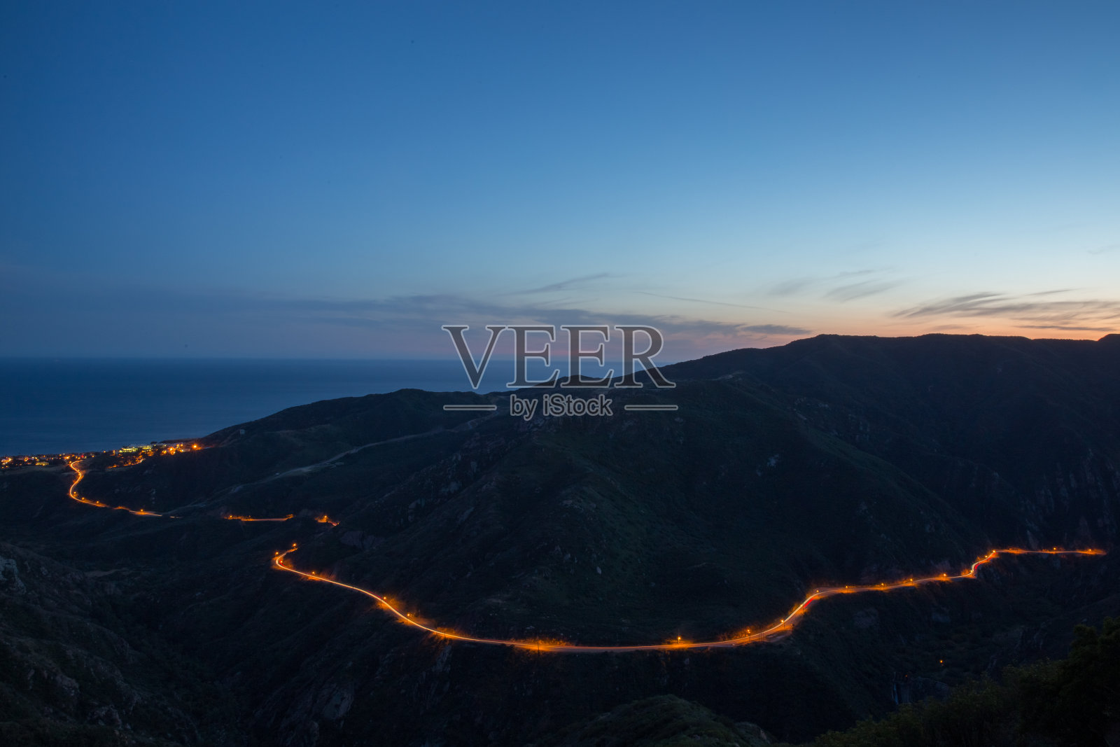 汽车灯光照亮了加州马里布的沿海高速公路照片摄影图片
