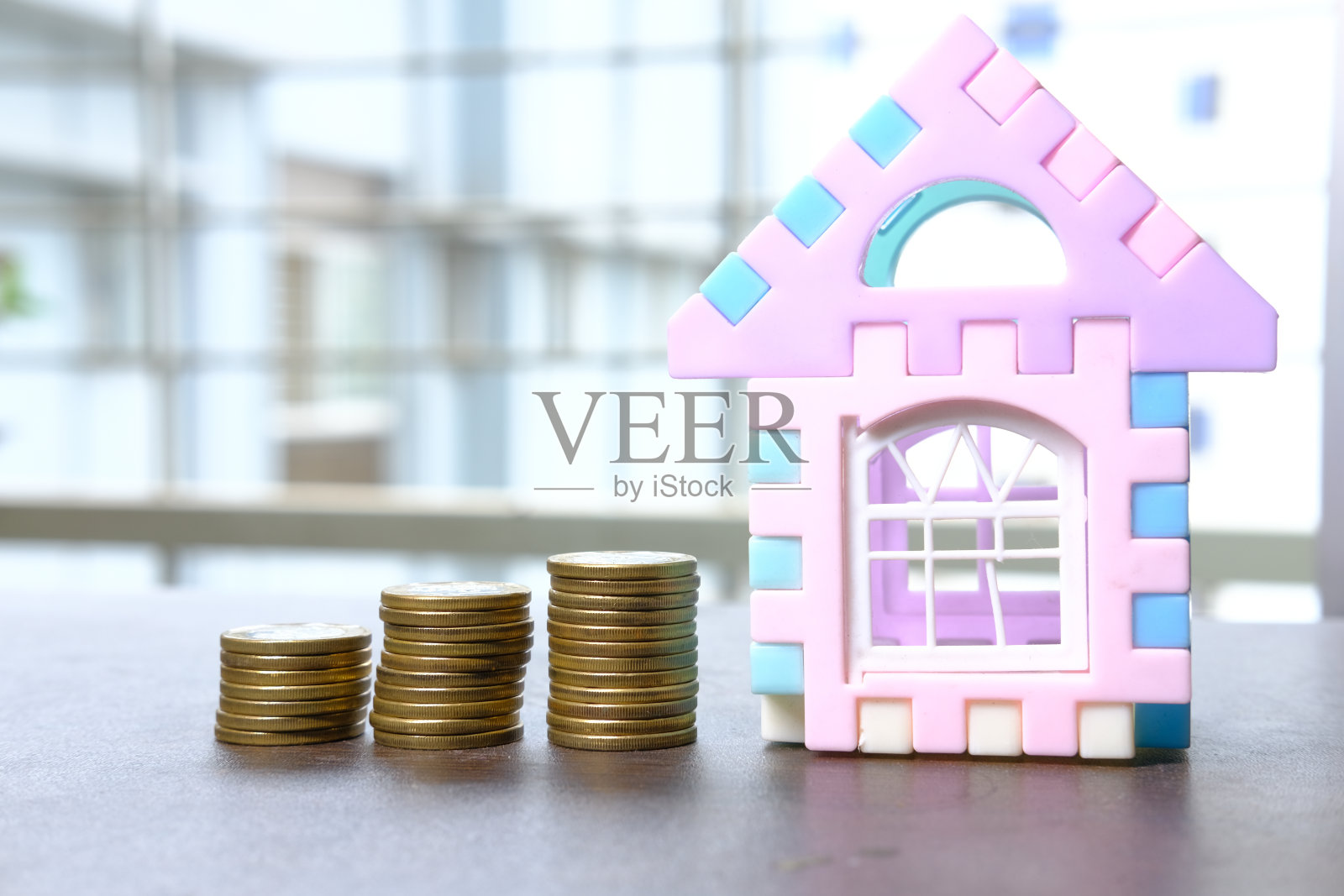 房子融资的概念是一堆硬币和一张桌子上的房子照片摄影图片