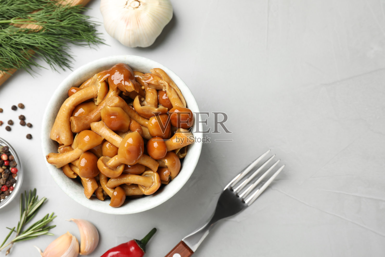 美味的腌蘑菇，大蒜和莳萝放在灰色的桌子上，平铺着。空间的文本照片摄影图片