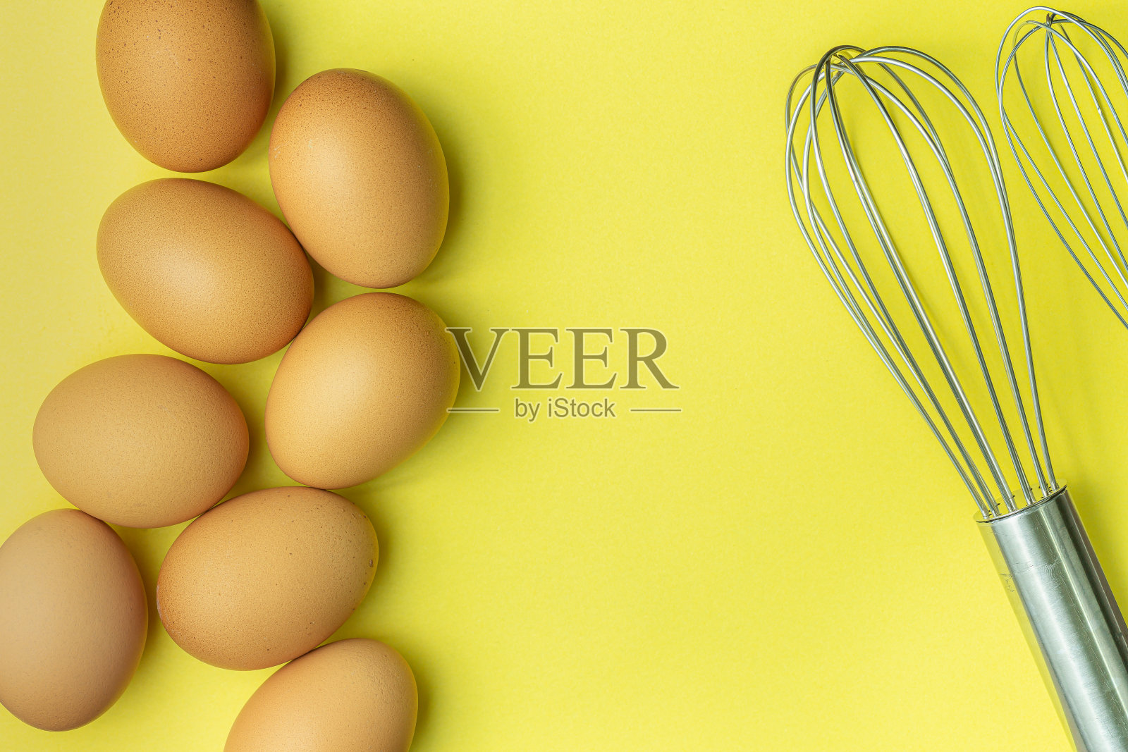 鸡蛋和打蛋器在黄色的背景，鸡蛋，棕色的鸡蛋，破鸡蛋纸箱在黄色的背景。俯视图天然鸡蛋纸箱产品概念照片摄影图片