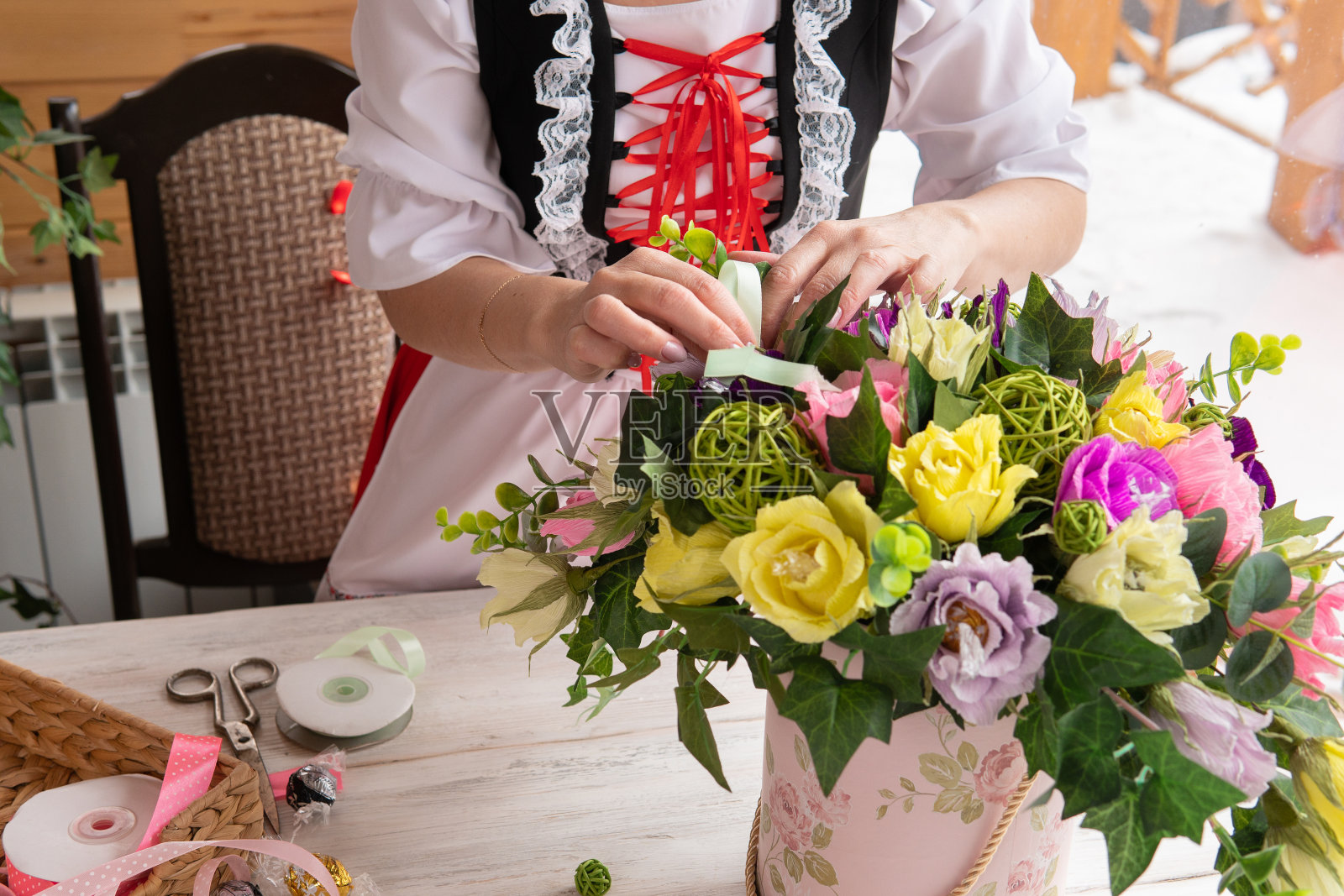 一个女人收集一束装饰性的纸花。照片摄影图片
