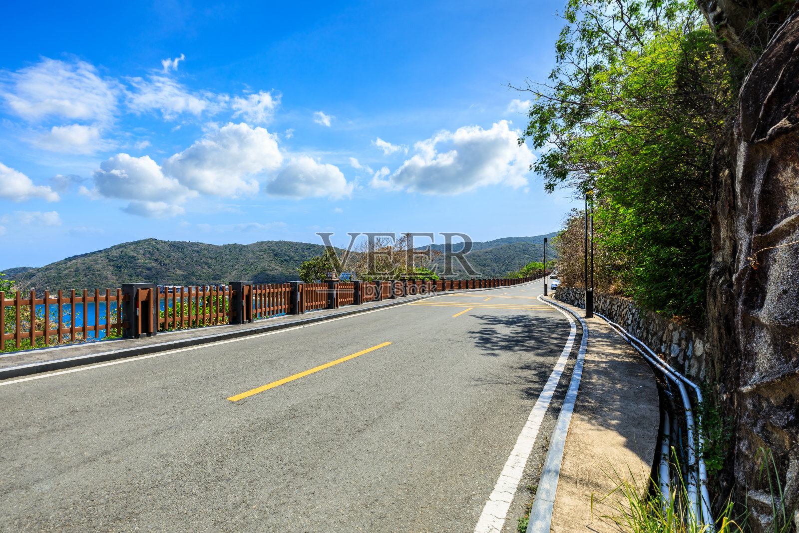 蓝天下的山路景观。照片摄影图片