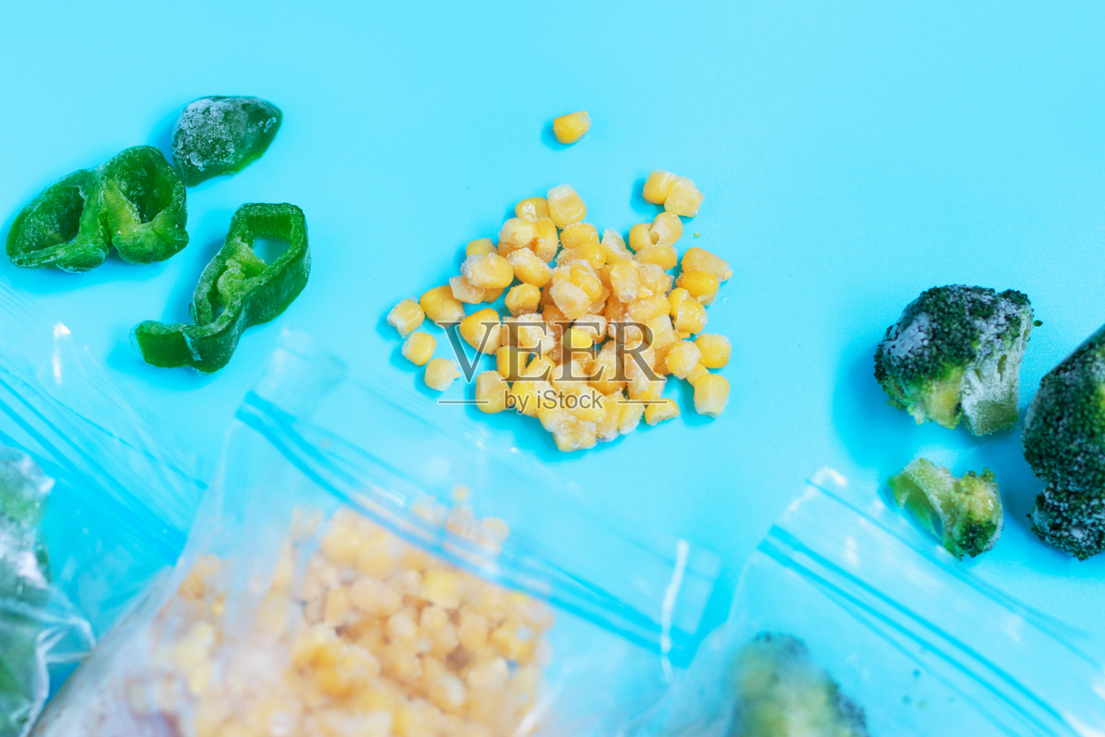 蓝色背景上的冰冻蔬菜包装特写。照片摄影图片
