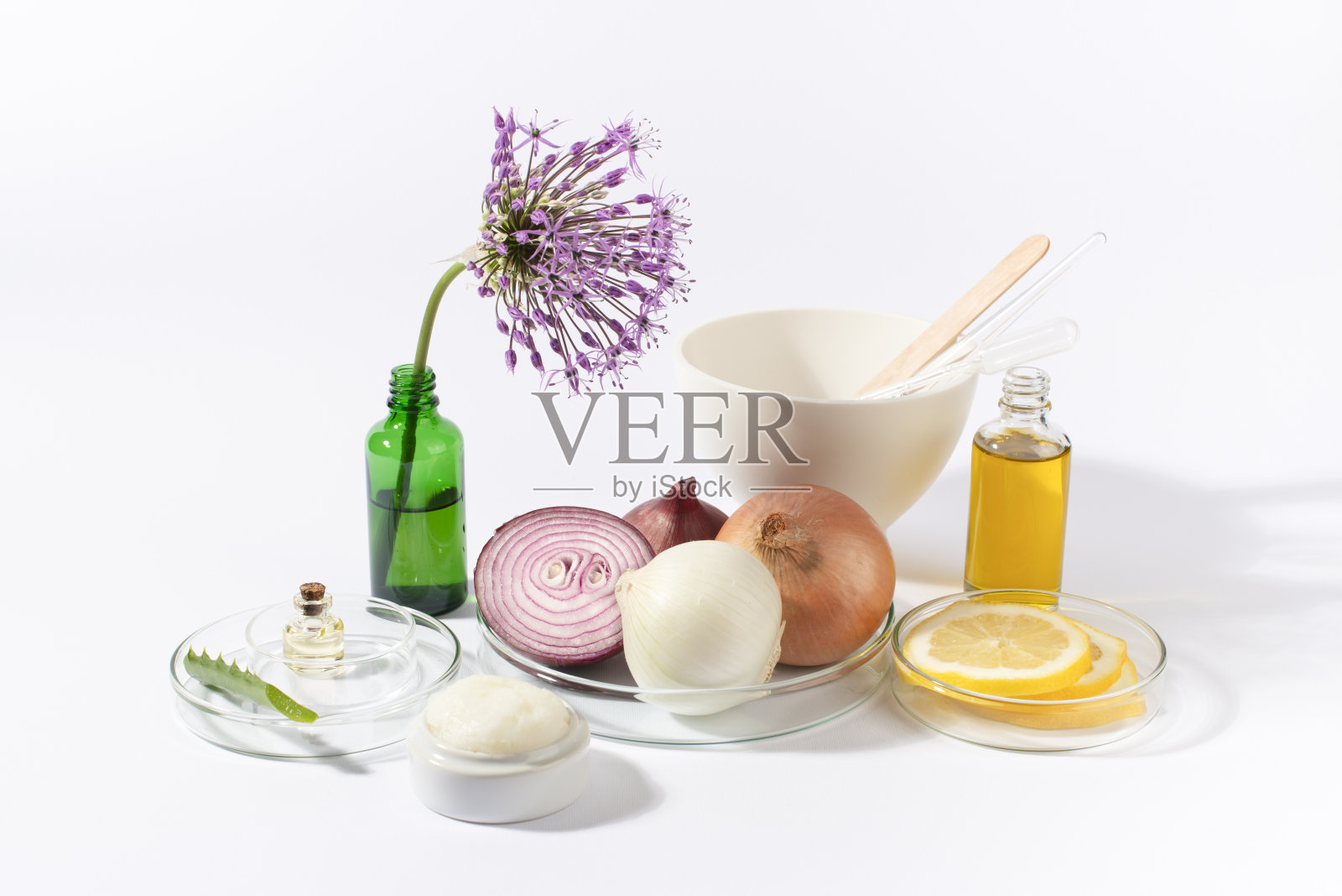洋葱，实验室玻璃器皿与油，奶油，柠檬，芦荟，大蒜花在白色的背景。照片摄影图片