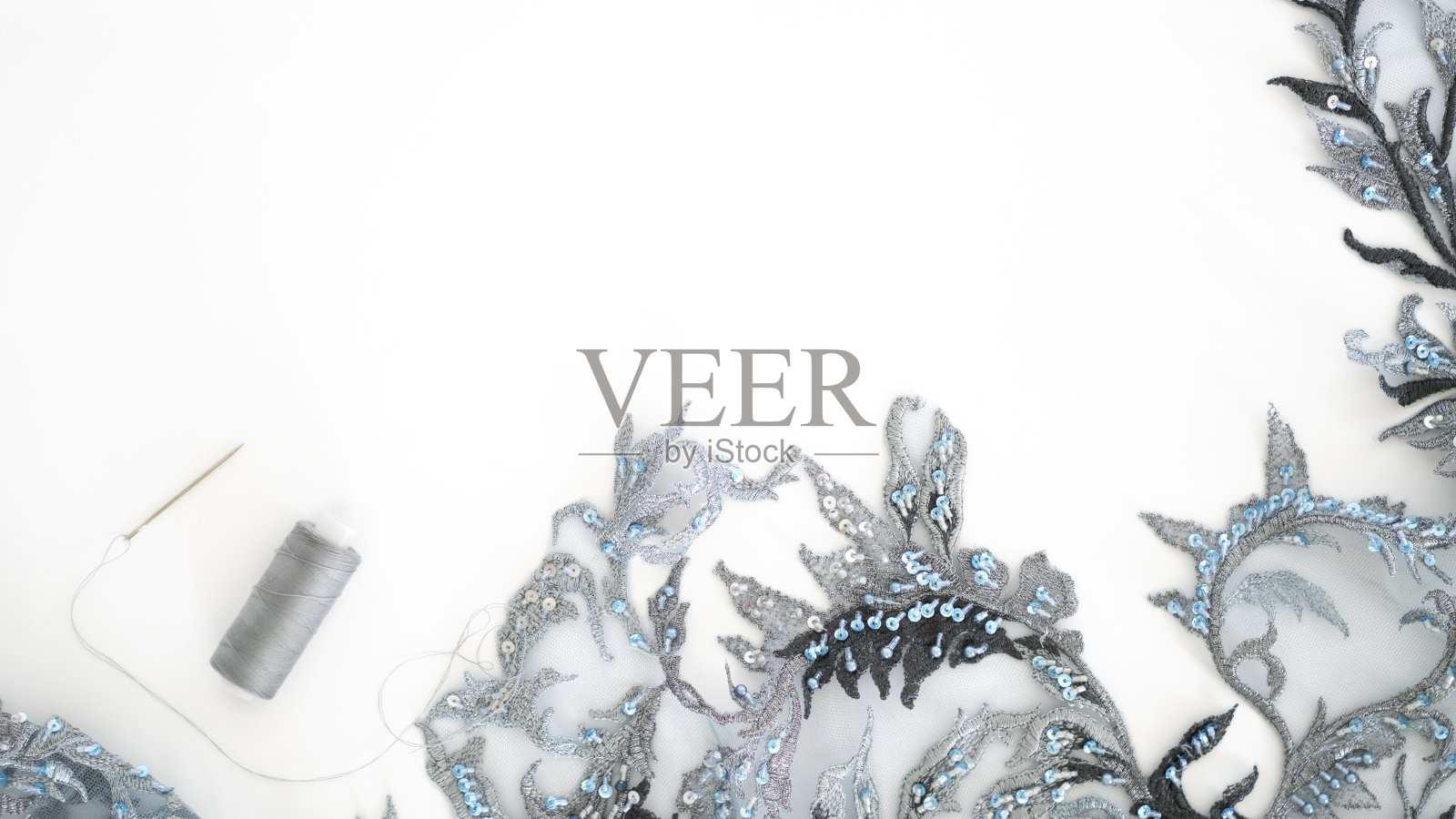 顶视图的女裁缝工作场所与蓝色和深蓝色薄纱面料蕾丝和珠子，针，线轴。有选择性的重点。副本的空间。平的。照片摄影图片