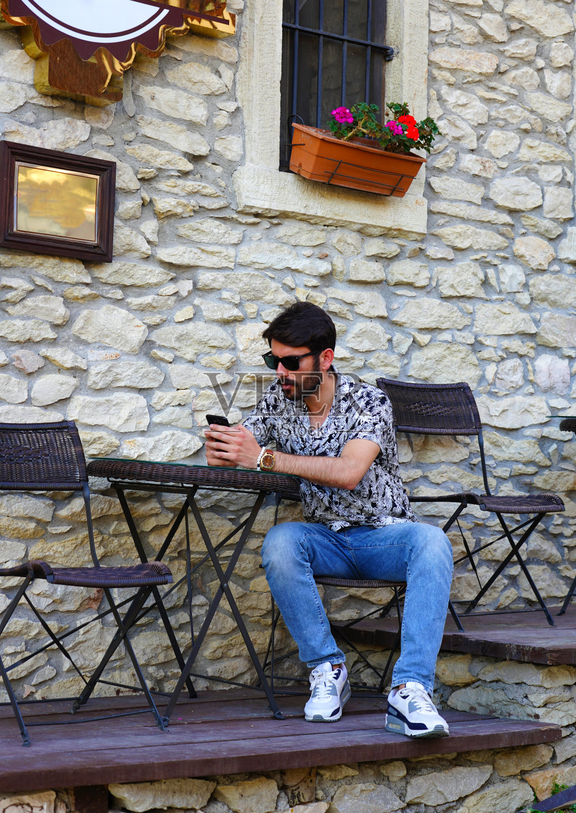 英俊的年轻男性感兴趣的电话在咖啡馆，Safranbolu，土耳其照片摄影图片