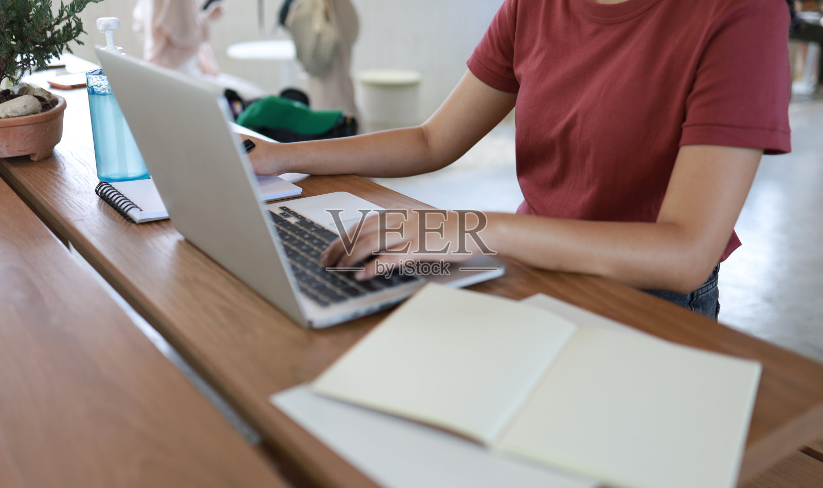 戴着防护面具在咖啡馆工作的女人。社交距离是指人们在公共社会中保持距离，以保护新冠肺炎照片摄影图片