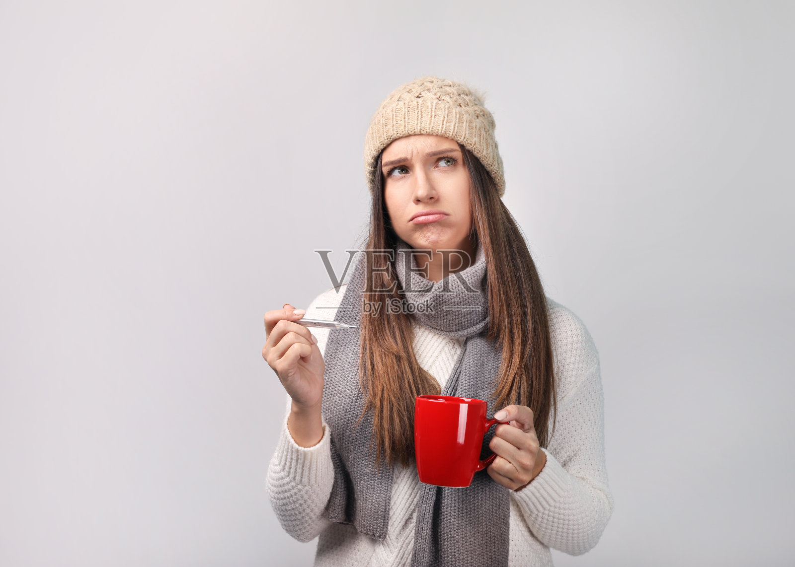 美丽的年轻女子在灰色背景下变得冷漠照片摄影图片