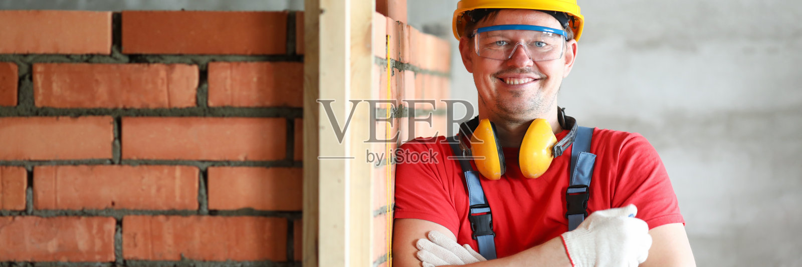 泥工或工头站在墙边施工照片摄影图片