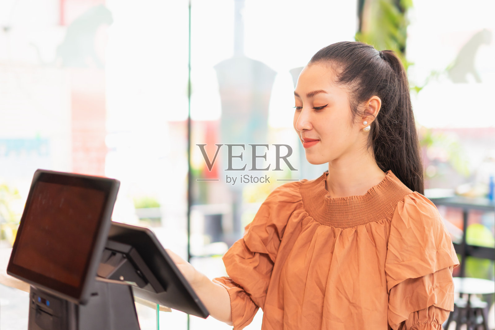 左边美丽的亚洲女人顾客高兴地选择咖啡的种类在收银台屏幕前的咖啡吧照片摄影图片