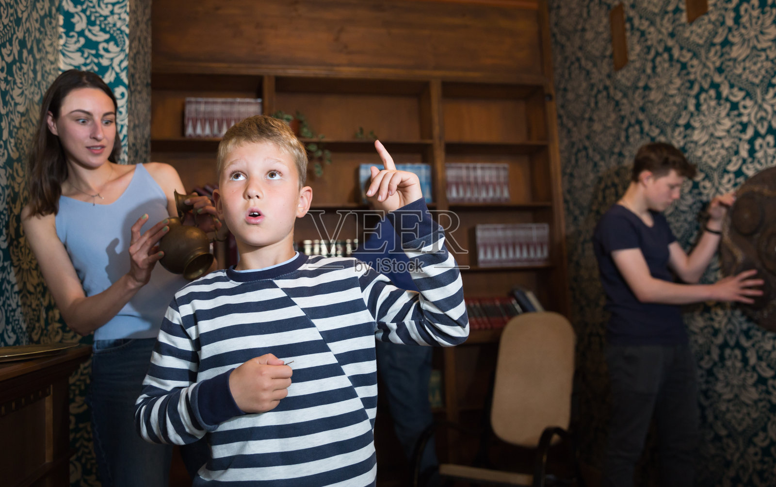 一个友好的家庭正试图找到一个解决谜题的房间照片摄影图片