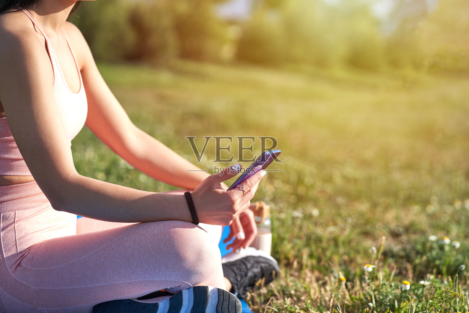 女性模特与运动服和健康的身体看智能手机照片摄影图片