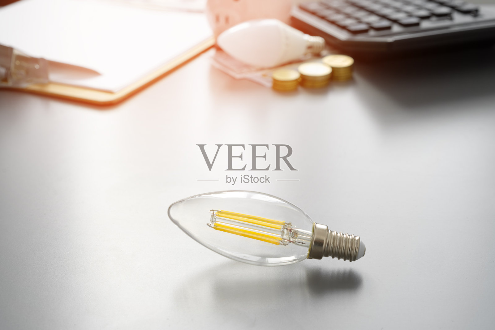 灯泡和计算器放在灰色的桌子上照片摄影图片