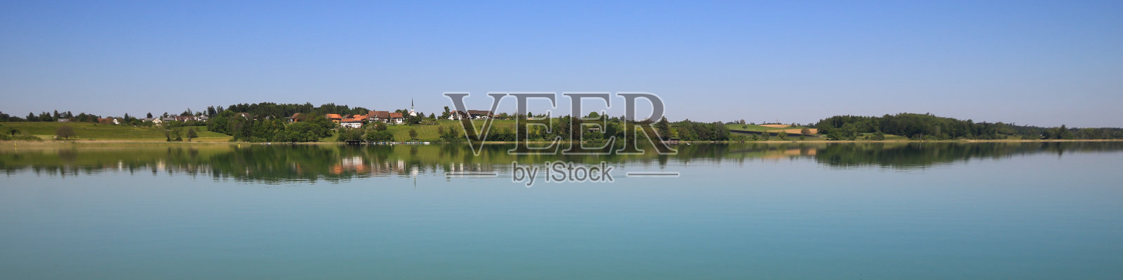 田园风光反映在普法菲肯湖，普法菲肯。古老的村庄Seegraben, Seegraeben。瑞士苏黎世，一个平静的春天早晨。照片摄影图片