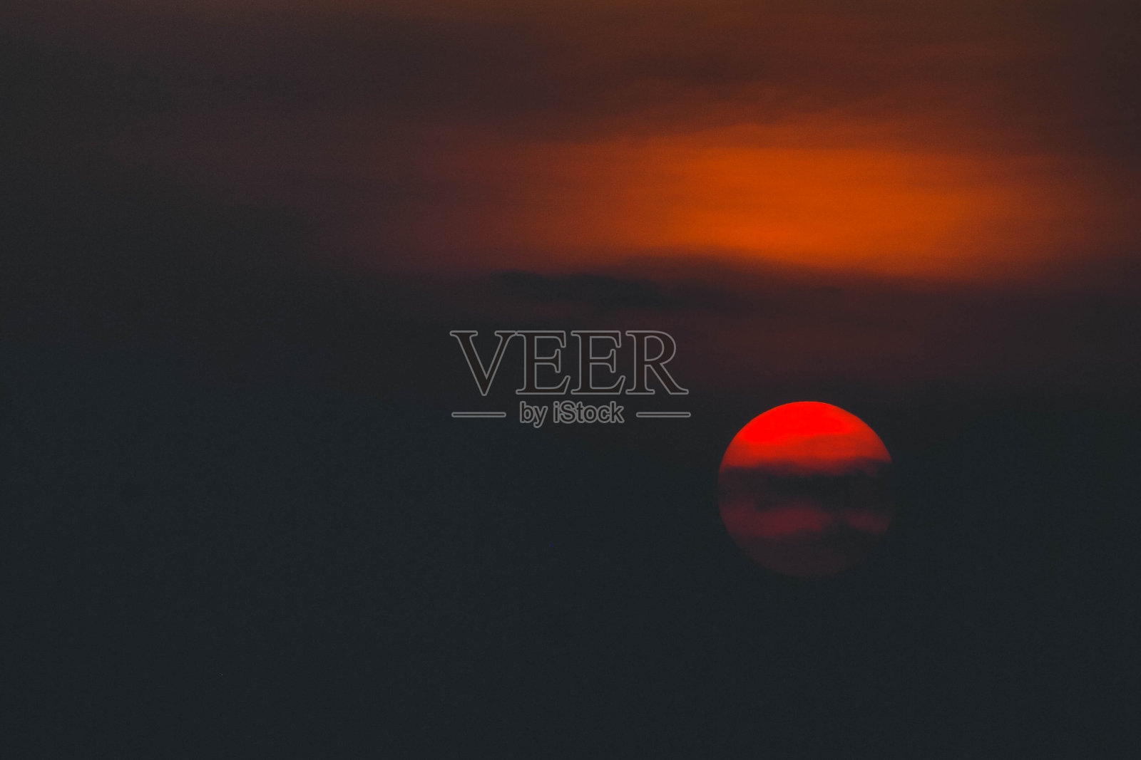 美丽的日落戏剧性的火红太阳被云包围在日落照片摄影图片