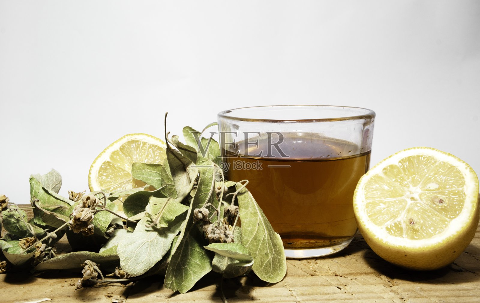 孤立的椴树茶和叶子在木盘上孤立的背景。照片摄影图片