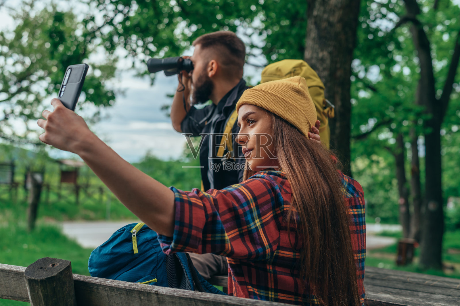 一对徒步旅行者用智能手机和双筒望远镜自拍照片摄影图片