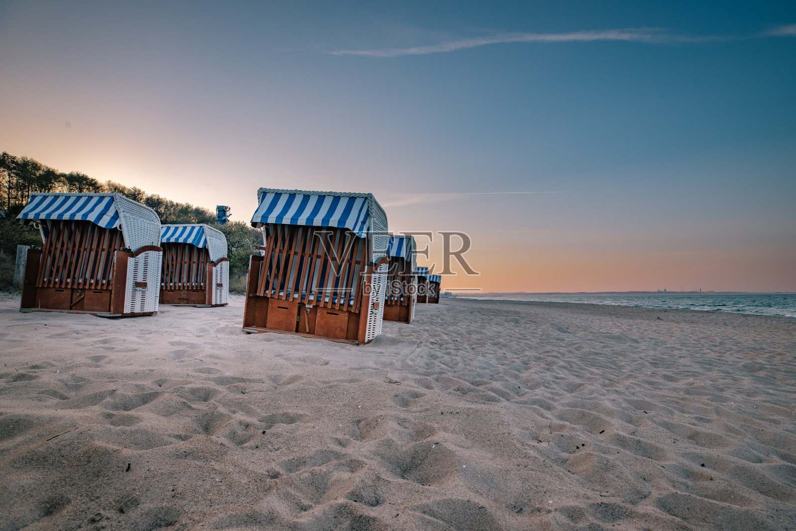 日落时德国沙伯茨的带帽沙滩椅照片摄影图片