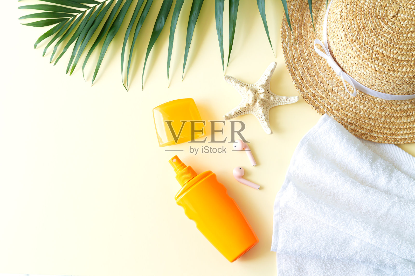 夏季女性海滩配件俯视图:帽子，防晒霜，棕榈叶，海星，毛巾和耳机照片摄影图片