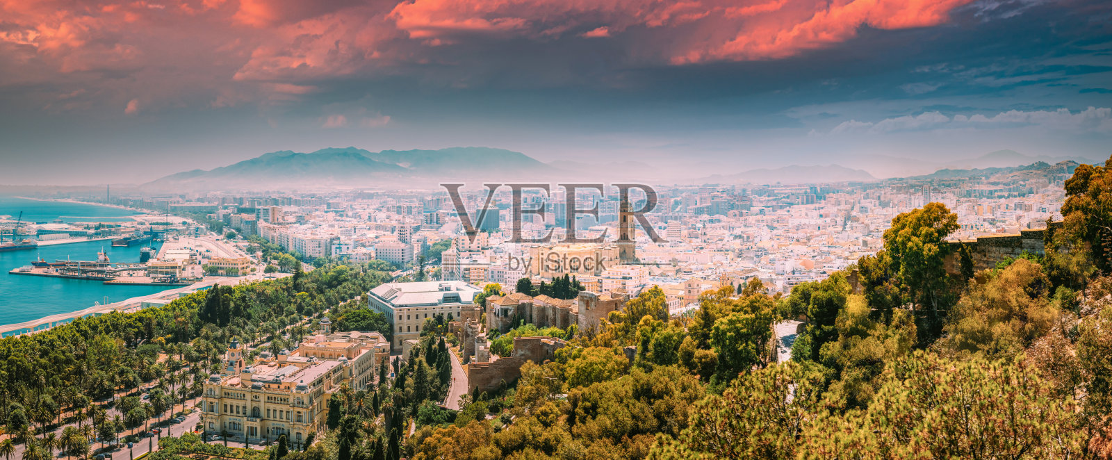 西班牙马拉加。马拉加在阳光明媚的夏天晚上的全景城市景观。改变了日落的天空照片摄影图片