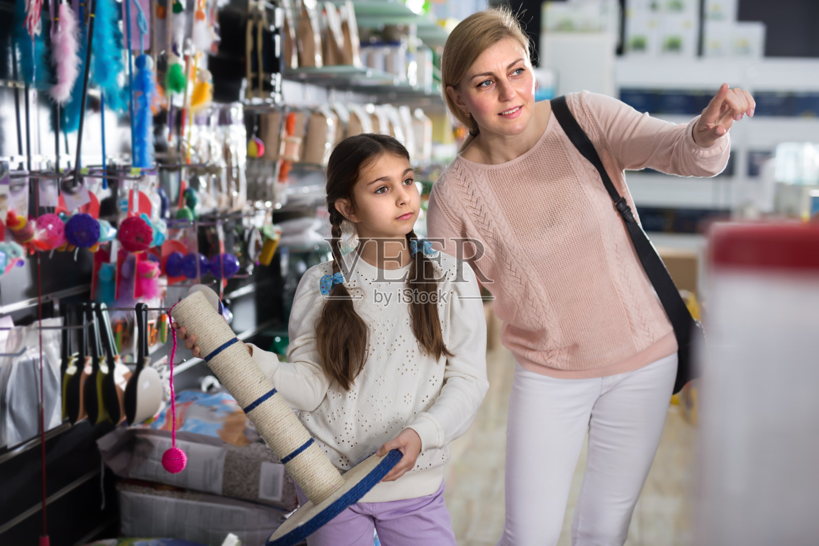 一个女人带着女儿去宠物店买抓挠柱照片摄影图片