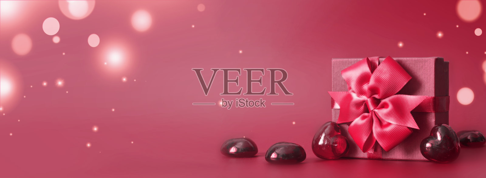 情人节概念横幅与手工制作的礼盒，弓，和许多心在红色的背景与文字的空间。照片摄影图片