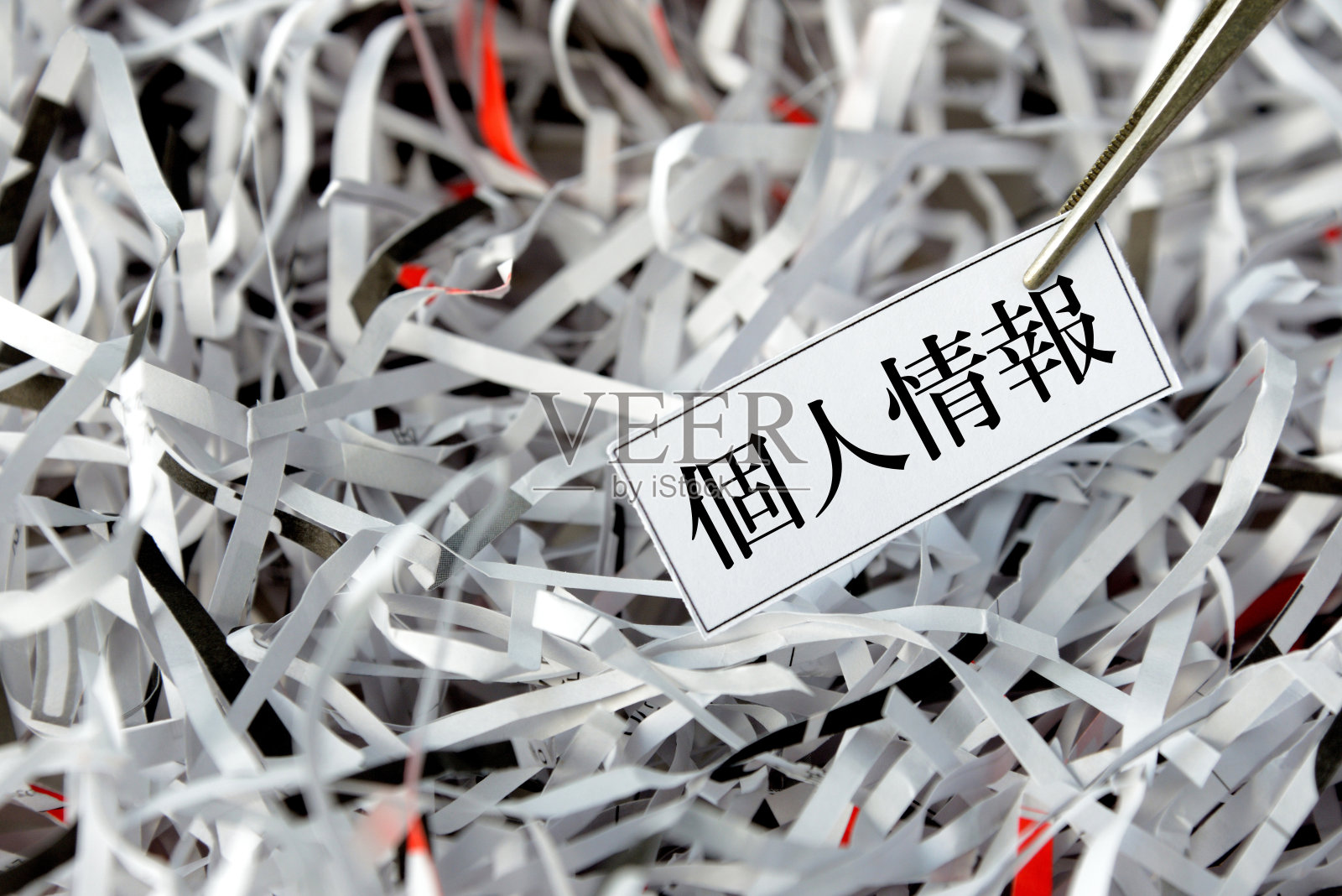 从撕碎的文件中挑选出带有日语信息单词的纸标签照片摄影图片