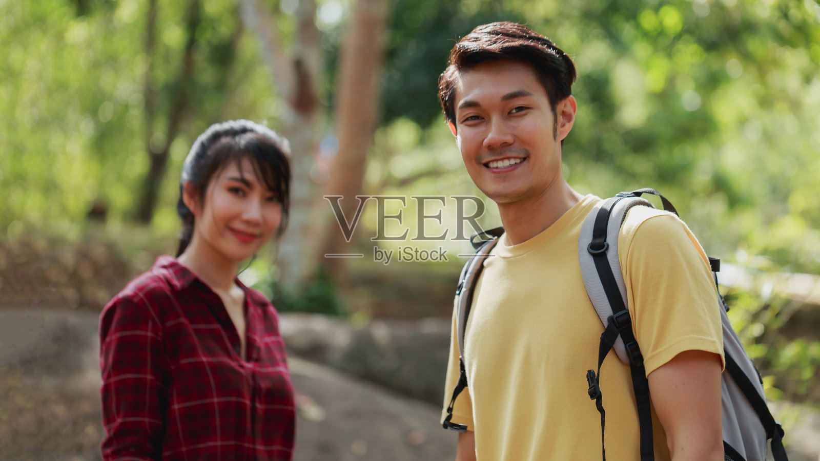 幸福的夫妇在森林户外徒步旅行。活跃的年轻亚洲女人和男人在大自然中寻找露营地点。成人夏季活动概念照片摄影图片