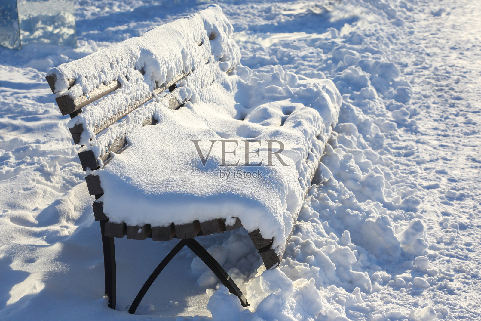 在冬天的公园里，白雪覆盖的长凳可以休息照片摄影图片
