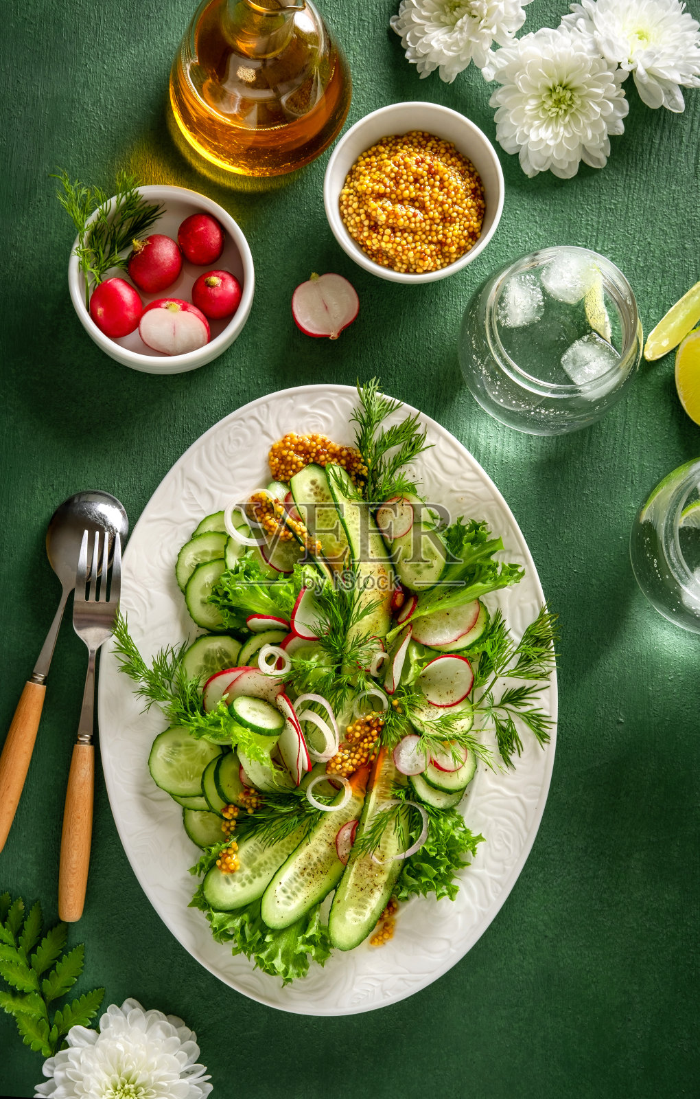夏季健康蔬菜沙拉，以黄瓜，萝卜和西红柿在绿色的背景。健康食品。照片摄影图片