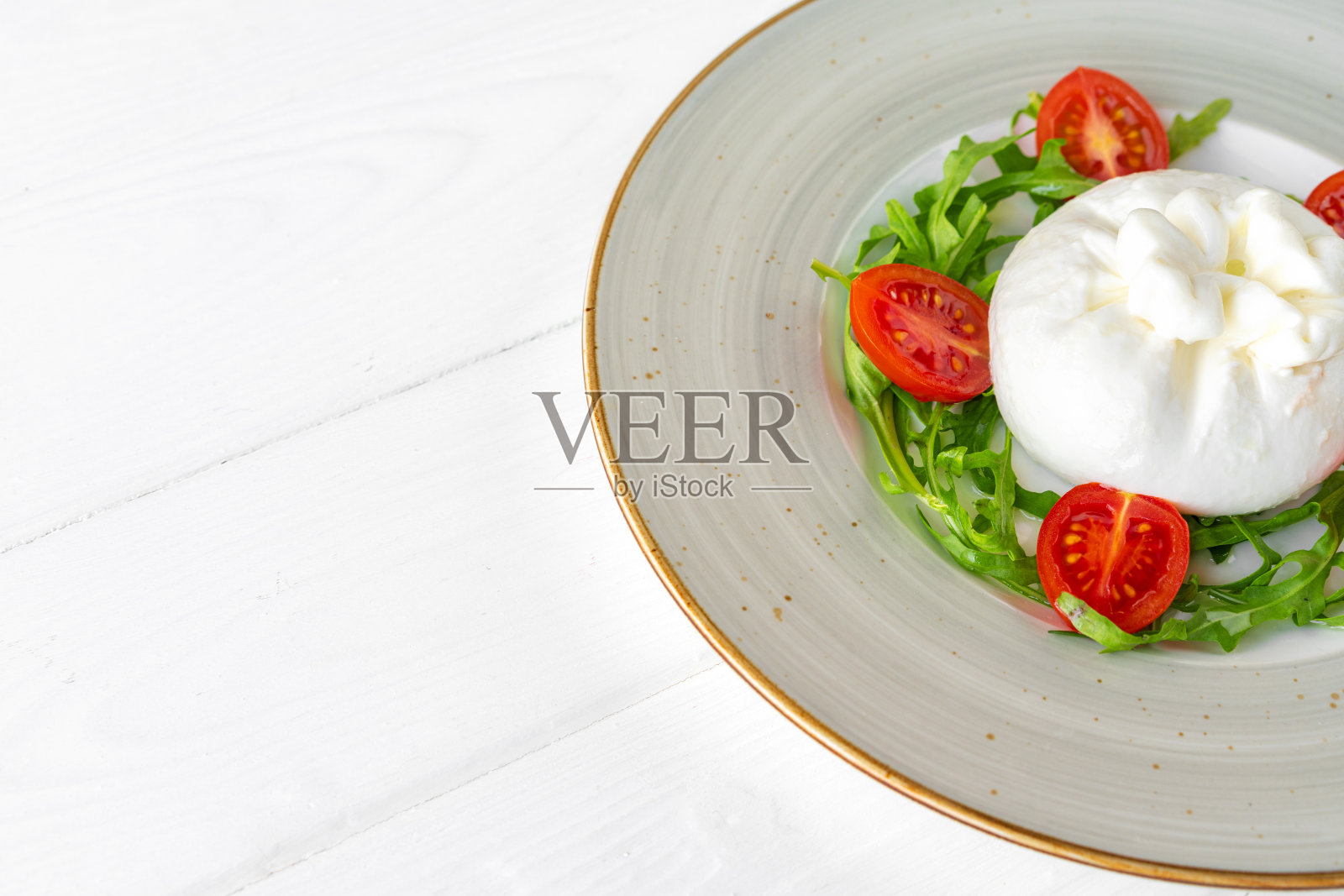 白木背景上的布拉塔芝士和樱桃番茄沙拉照片摄影图片