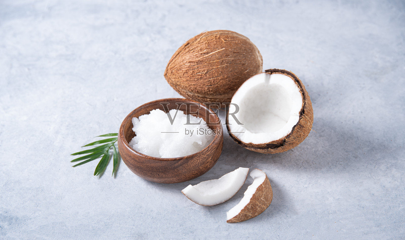健康的纯素椰子油和半椰子片在蓝色的背景。本空间照片摄影图片