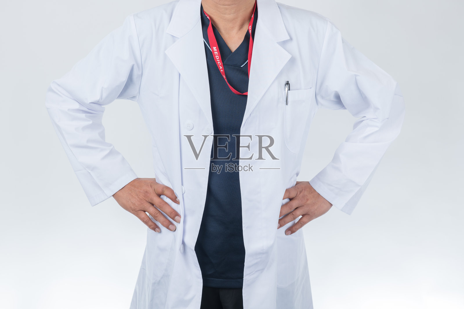 穿着白大褂的男医生，手放在屁股上照片摄影图片