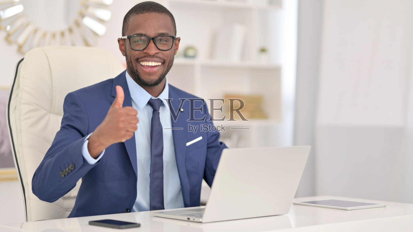 积极的非洲商人在笔记本电脑上竖起大拇指照片摄影图片
