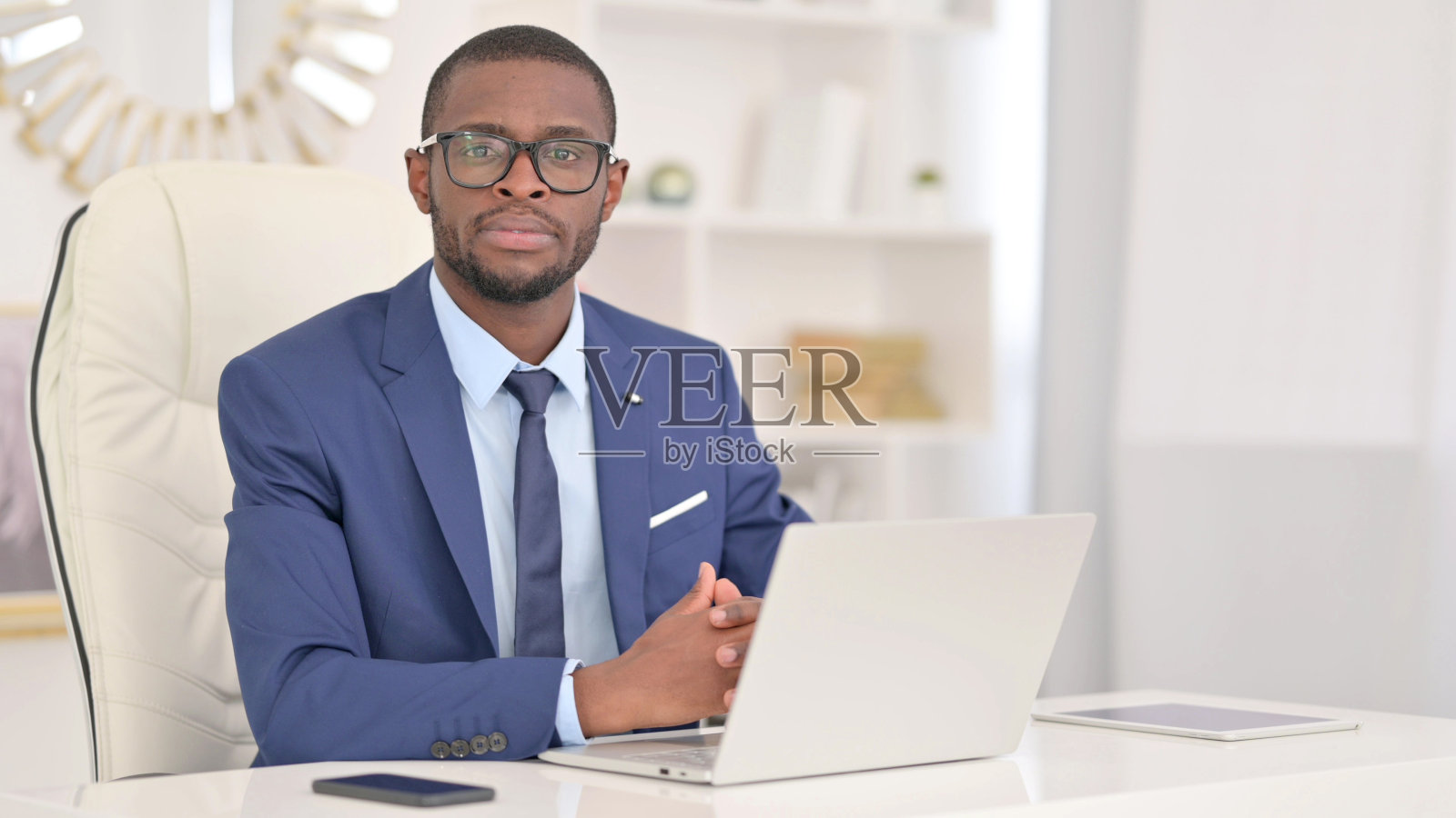 年轻的非洲商人用手提电脑看着相机照片摄影图片