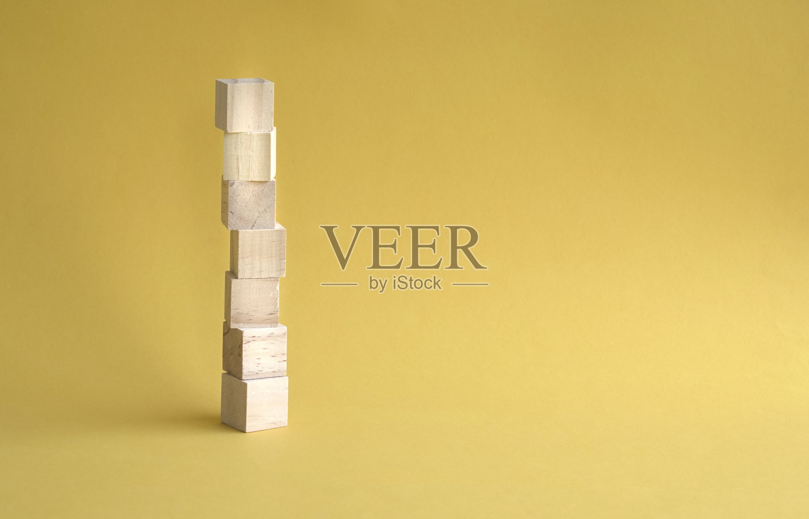 7字空白与木块叠放，黄色背景。副本的空间。照片摄影图片