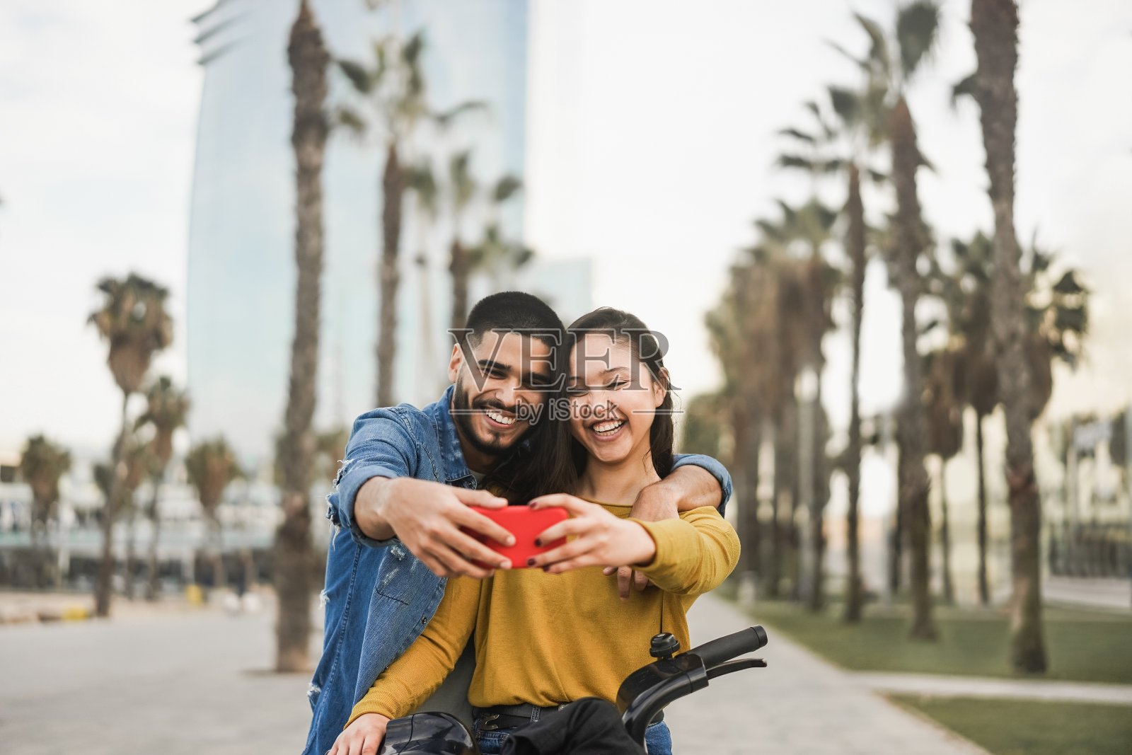 快乐的年轻人骑电动自行车在城市户外自拍-关注脸照片摄影图片