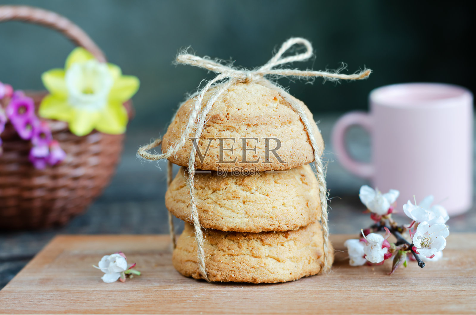 燕麦饼干放在木板上，鲜花和杯子。有选择性的重点照片摄影图片