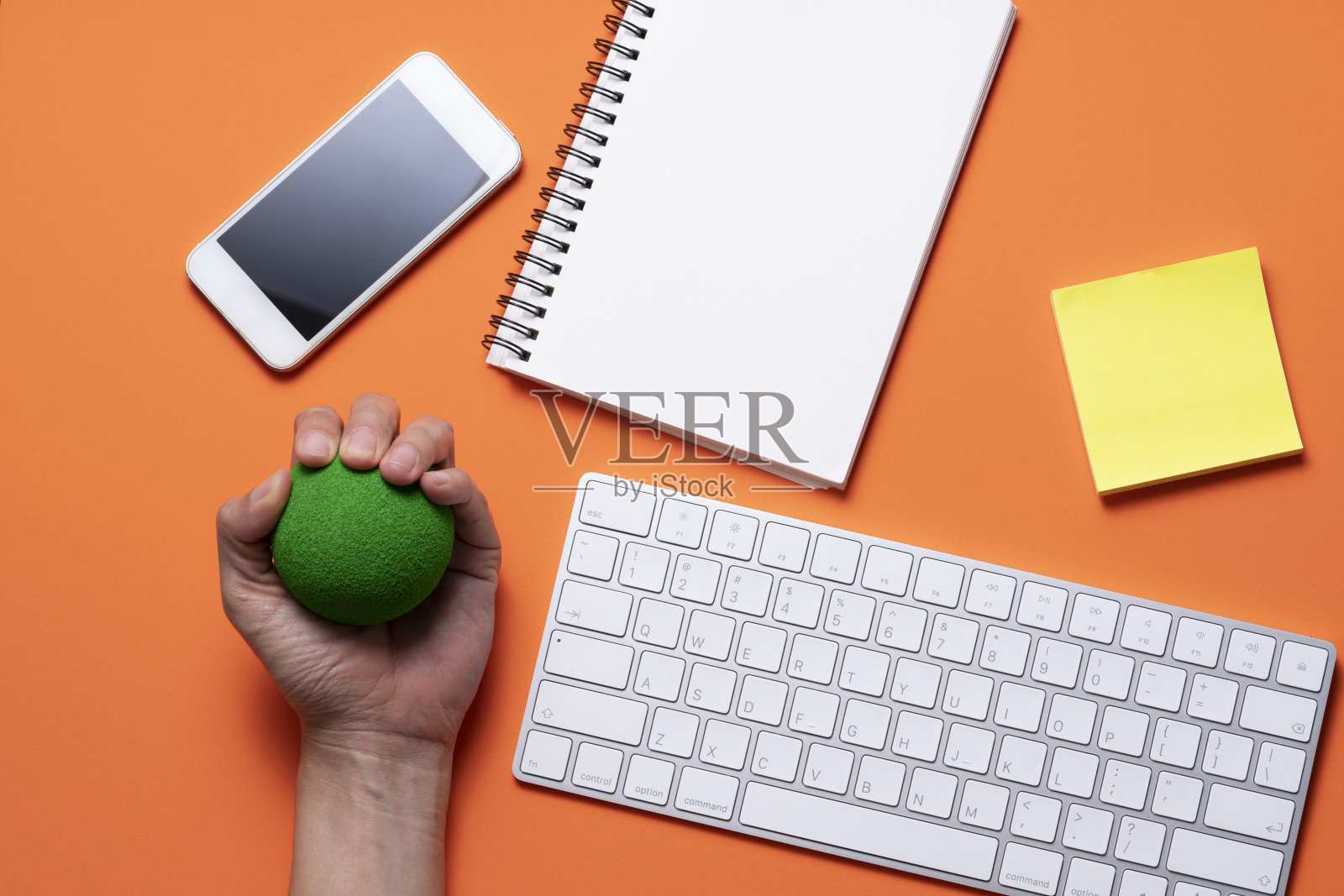 靠近电脑，压力球和键盘电脑与橙色的桌子背景在办公室，压力概念照片摄影图片