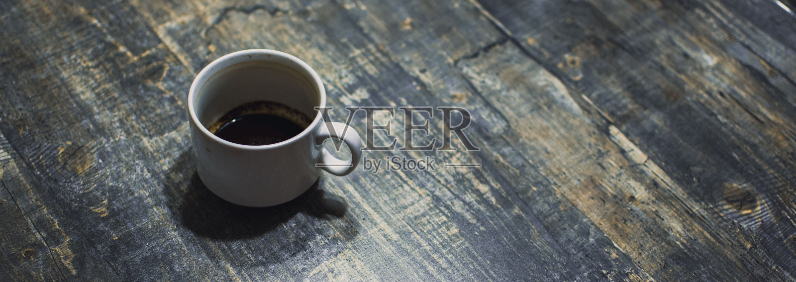 木桌上放着一只脏兮兮的白咖啡杯照片摄影图片