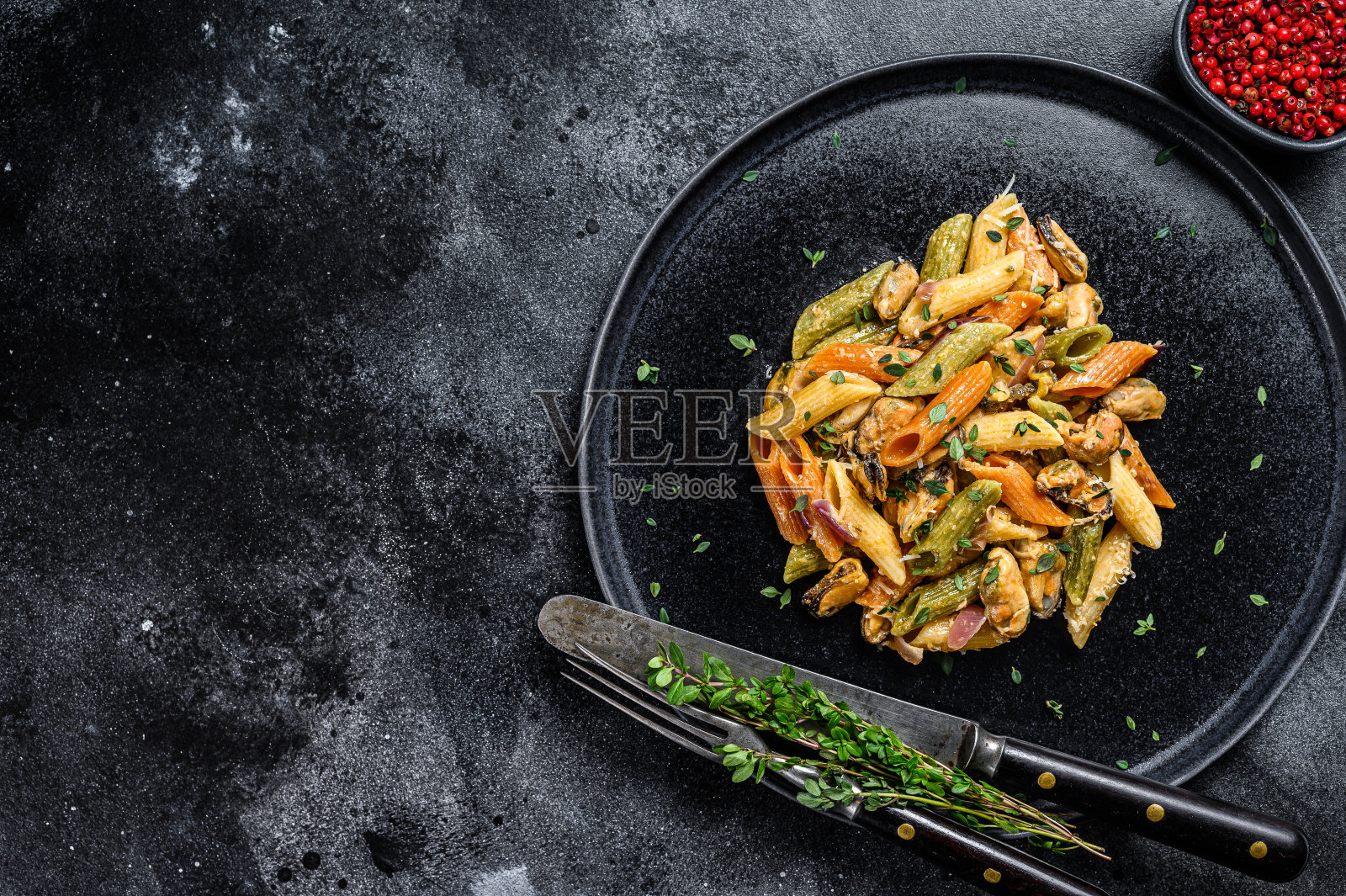 意大利彩色通心粉配贻贝。黑色背景。前视图。本空间照片摄影图片