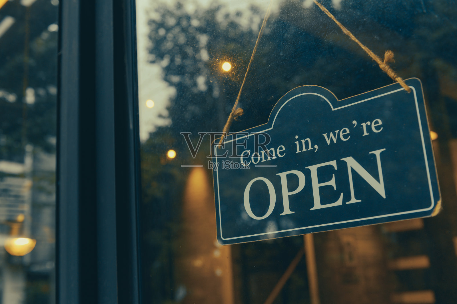 进来，我们是开放的——在咖啡店或餐厅的大门上贴着开放的标牌照片摄影图片