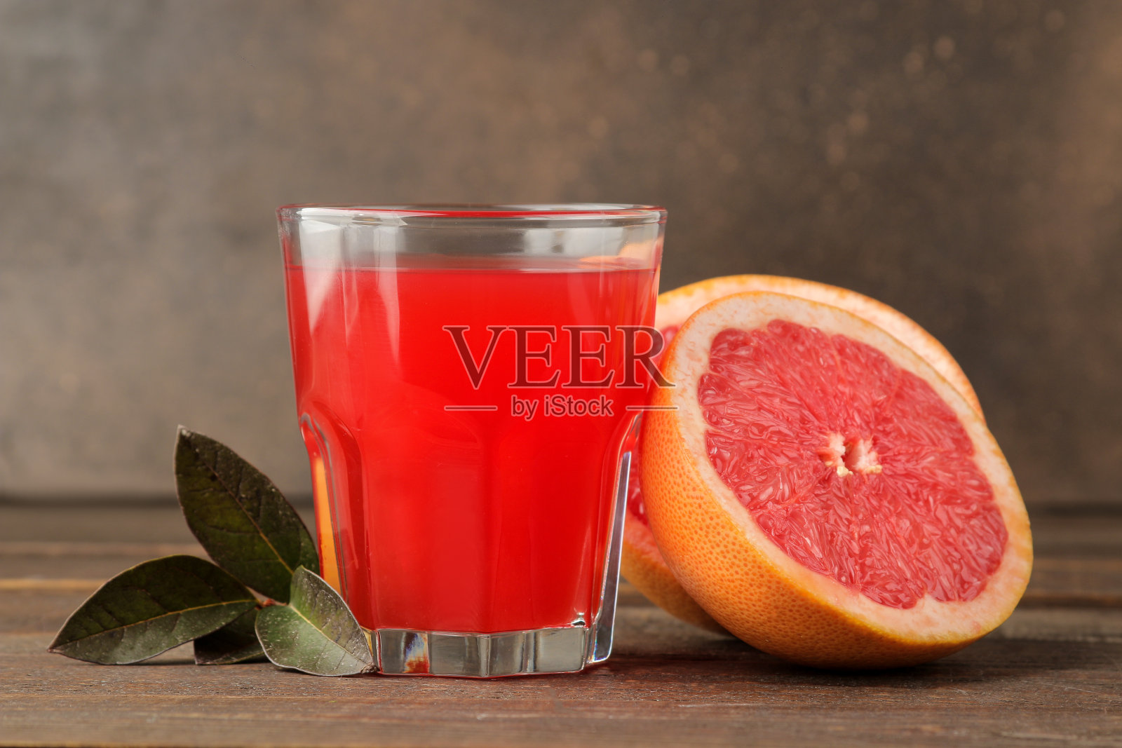 柑橘类果汁。柚子汁装在杯子里，新鲜的水果放在棕色的木桌上照片摄影图片
