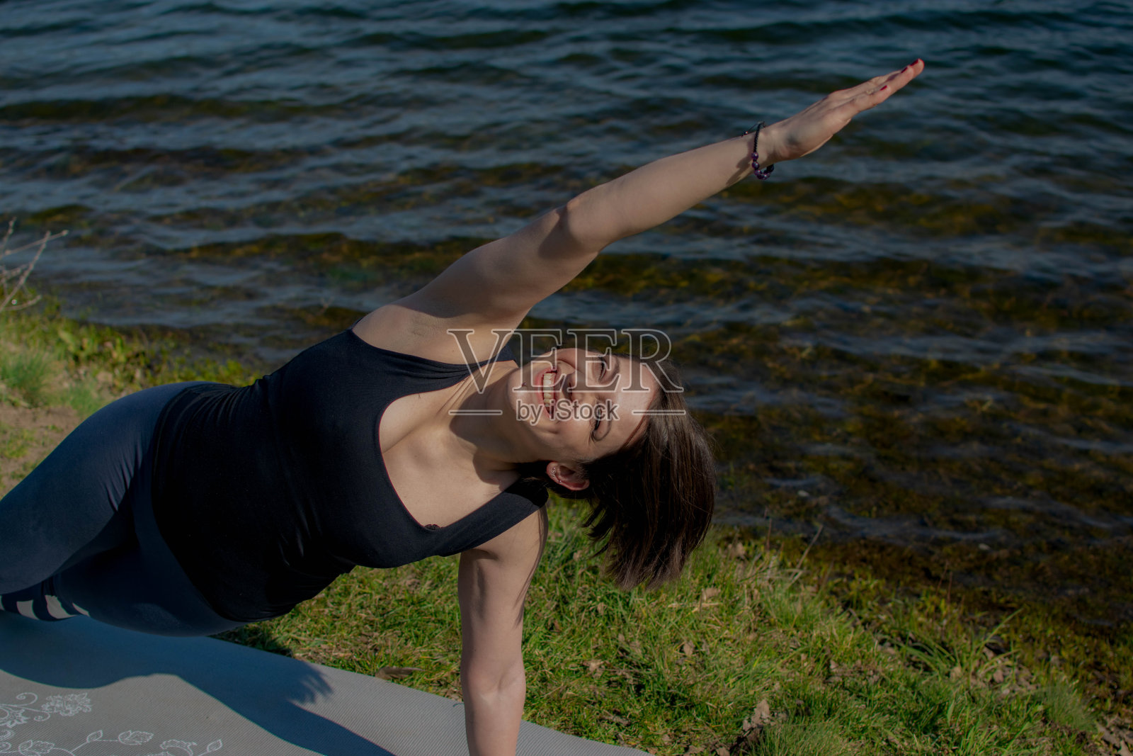 美丽快乐的女孩闭着眼睛练习瑜伽。在她的家里，健康的生活方式和瑜伽概念，特写。照片摄影图片