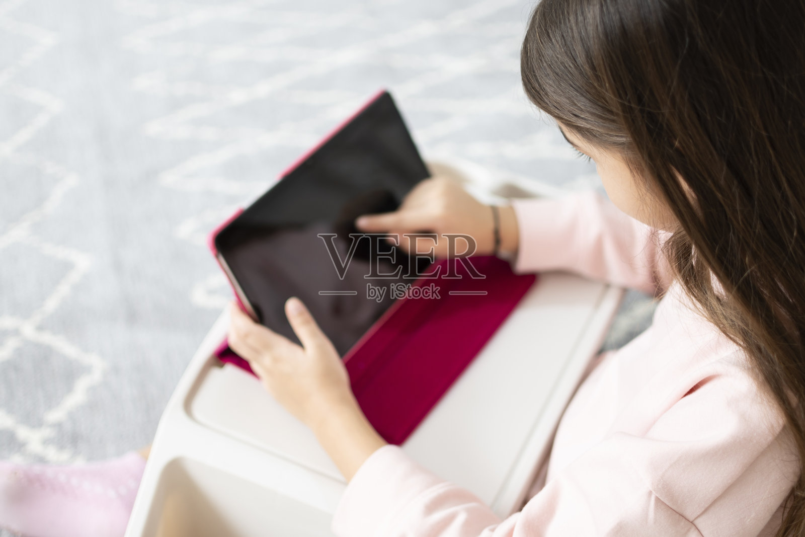 小女孩在家里的塑料桌上使用数码平板电脑照片摄影图片