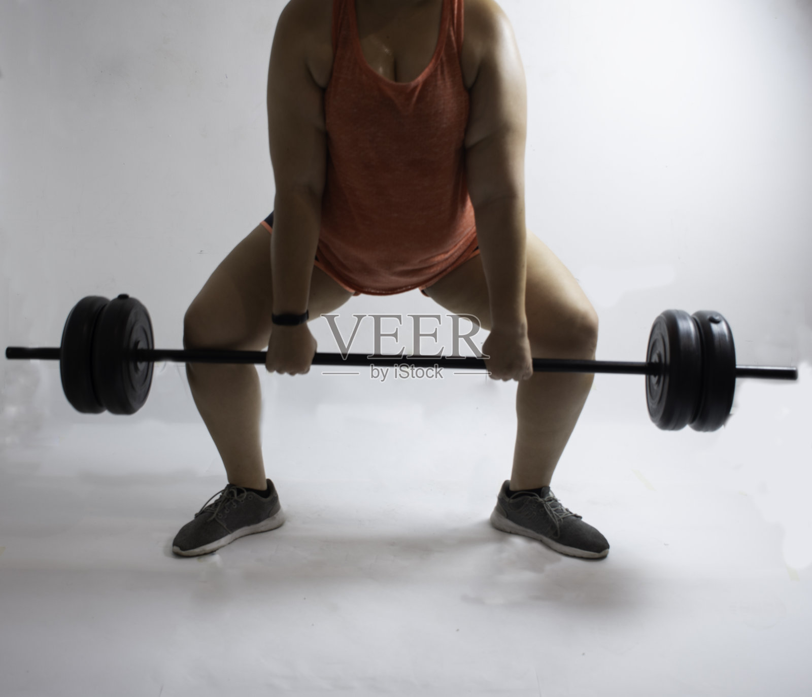 白人女子在白人背景下表演杠铃举重照片摄影图片