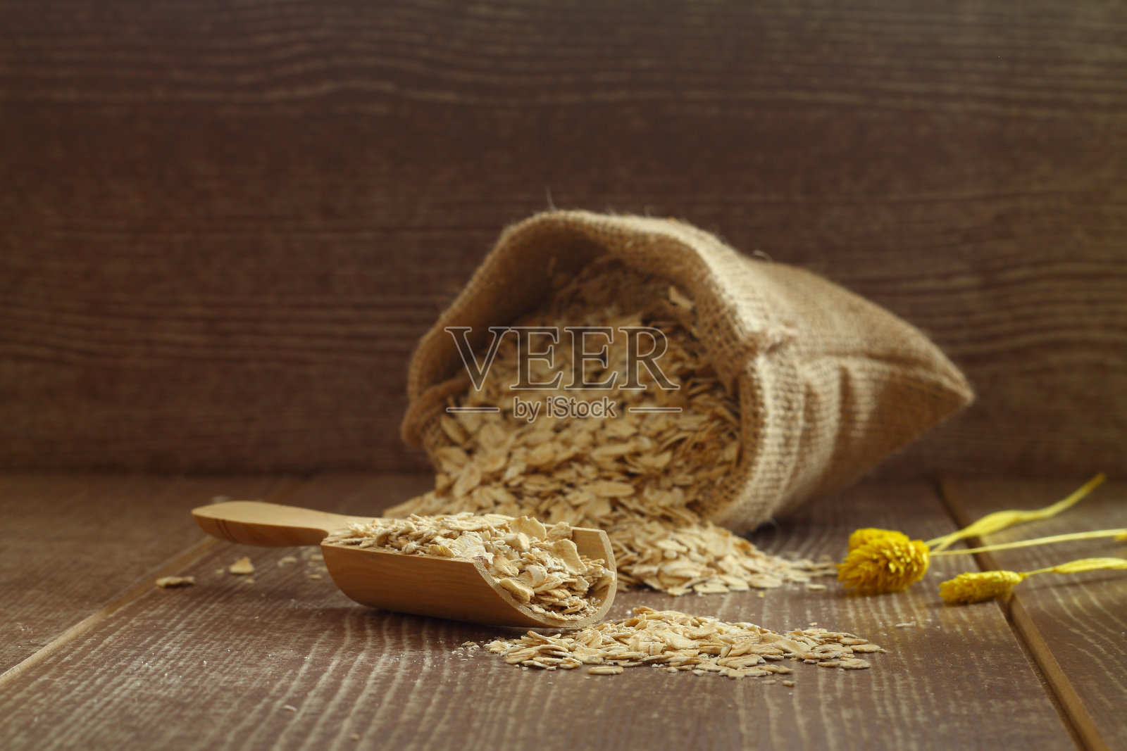 燕麦片装在袋子里，勺子放在木桌上照片摄影图片