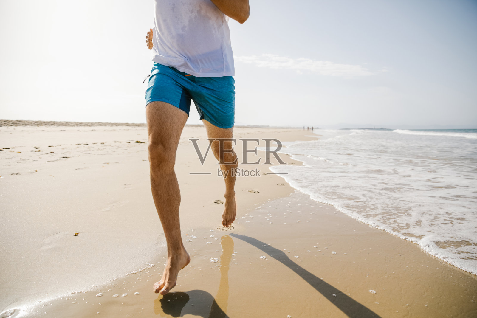 在海滩上奔跑的陌生年轻人照片摄影图片